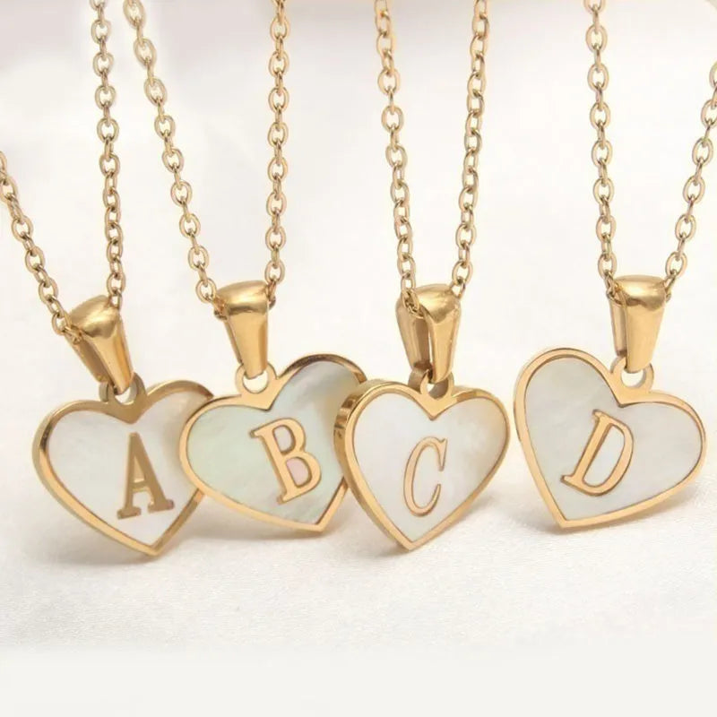 Gold-plated heart necklace with white shell pendant and initial personalisation on a stainless steel chain.