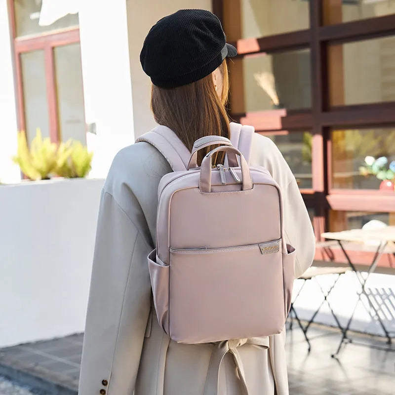 Canvas travel backpack for women in pink, black, or apricot with laptop sleeve and multiple internal pockets.