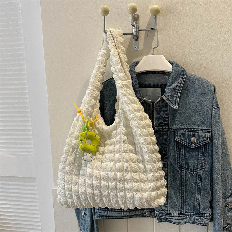 Soft pleated square bubble bag in beige with a removable pendant and single shoulder strap.