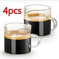 Two white double-mouthed transparent glass coffee cups on a table.