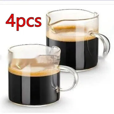 Two white double-mouthed transparent glass coffee cups on a table.