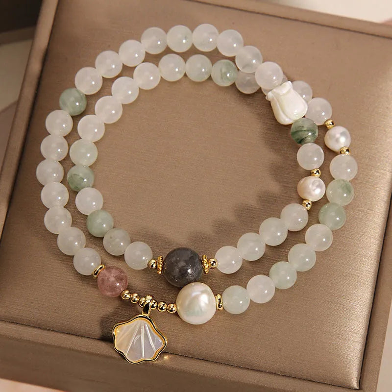 Women's crystal bracelet with gold ginkgo leaf pendant and rhinestones on a white background.
