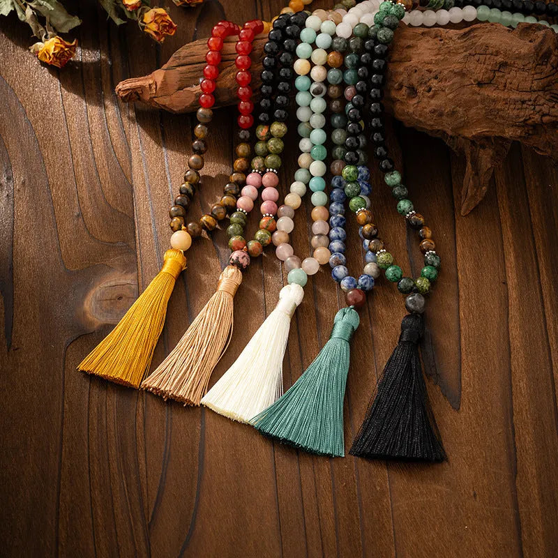 Vintage bohemian style long bead necklace with tassel and matching bracelet on grey background