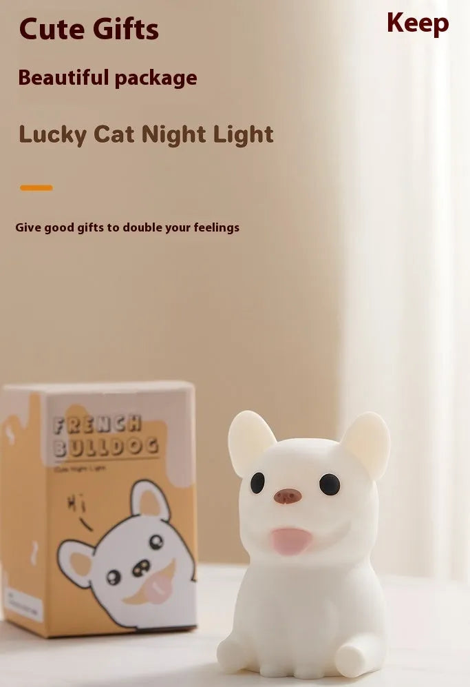 Soft silicone USB night light with dimmer in a cartoon animal design on a bedside table.