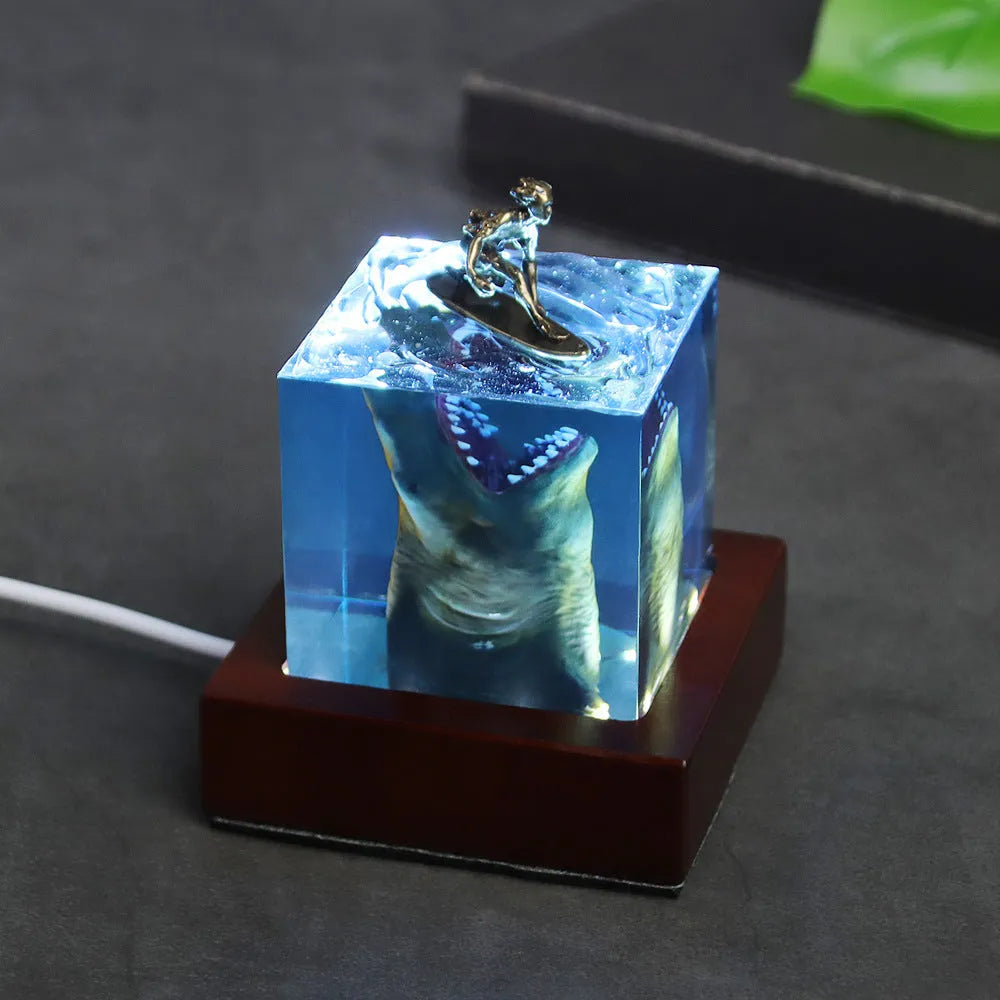 Clear epoxy resin ornament showing shark surfing on wave with integrated night light