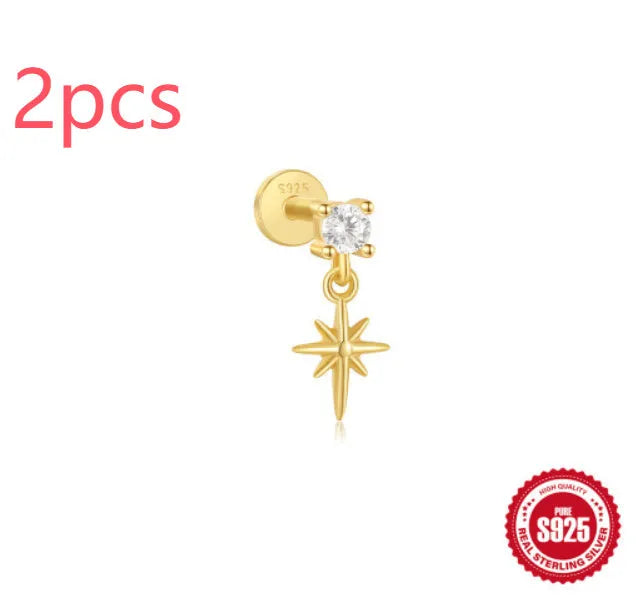 A gold tone sterling silver ear stud featuring a dangling tassel and XINGX inlaid design on the stud.