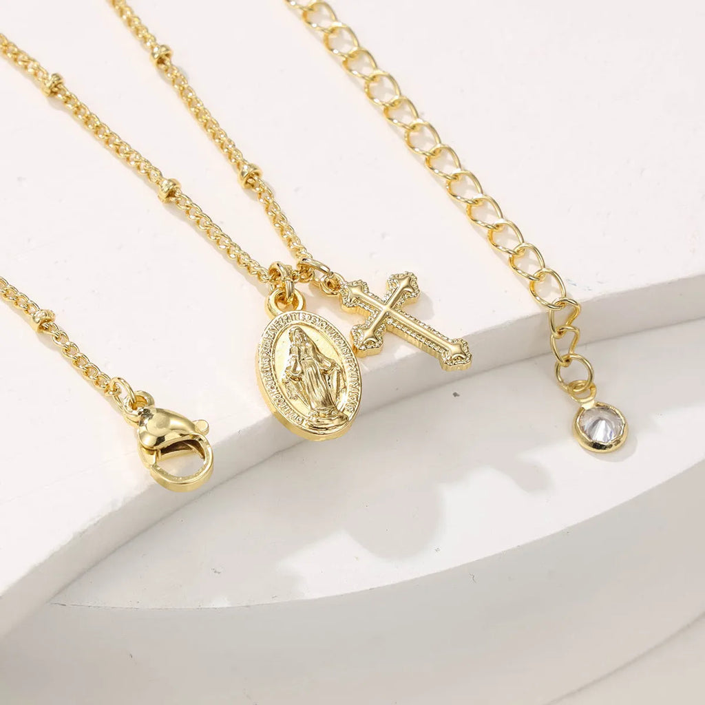 Gold geometric Virgin Mary cross necklace on a chain, simple style.