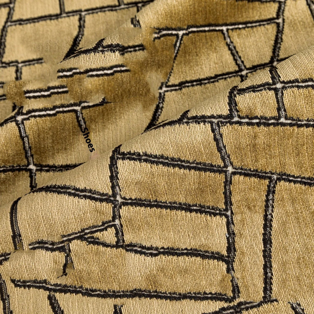 Gold geometric patterned decorative pillow on a grey sofa.