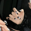 Hand-painted black peach heart artificial nails with bow design in four sizes