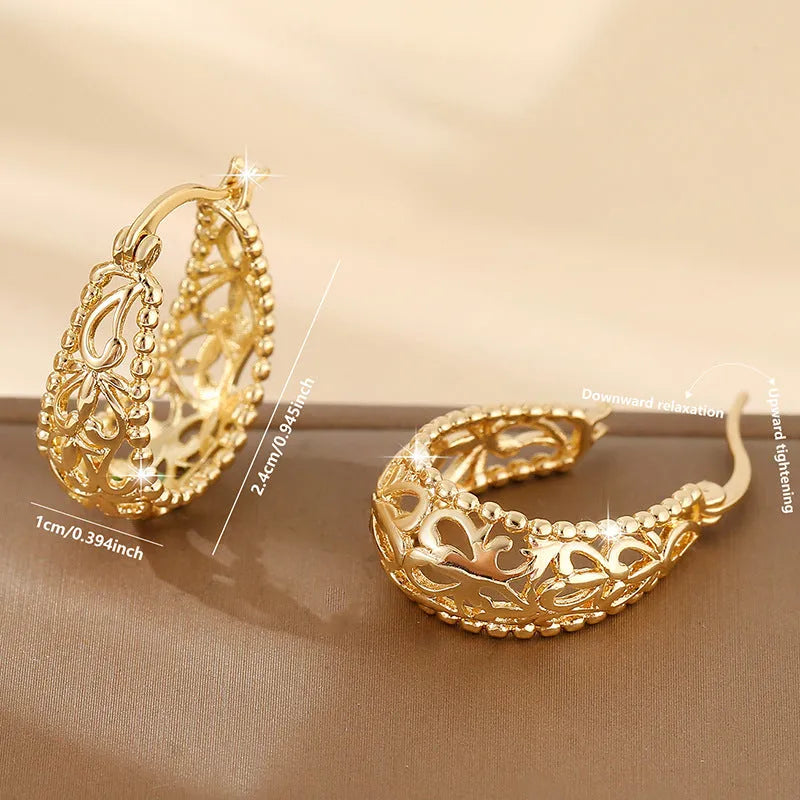 Gold copper geometric hollowed-out large earrings with round shape on neutral background
