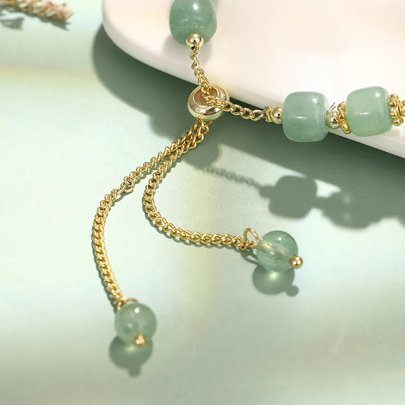 Rabbit charm bracelet with green natural stone beads and gold accents on adjustable chain
