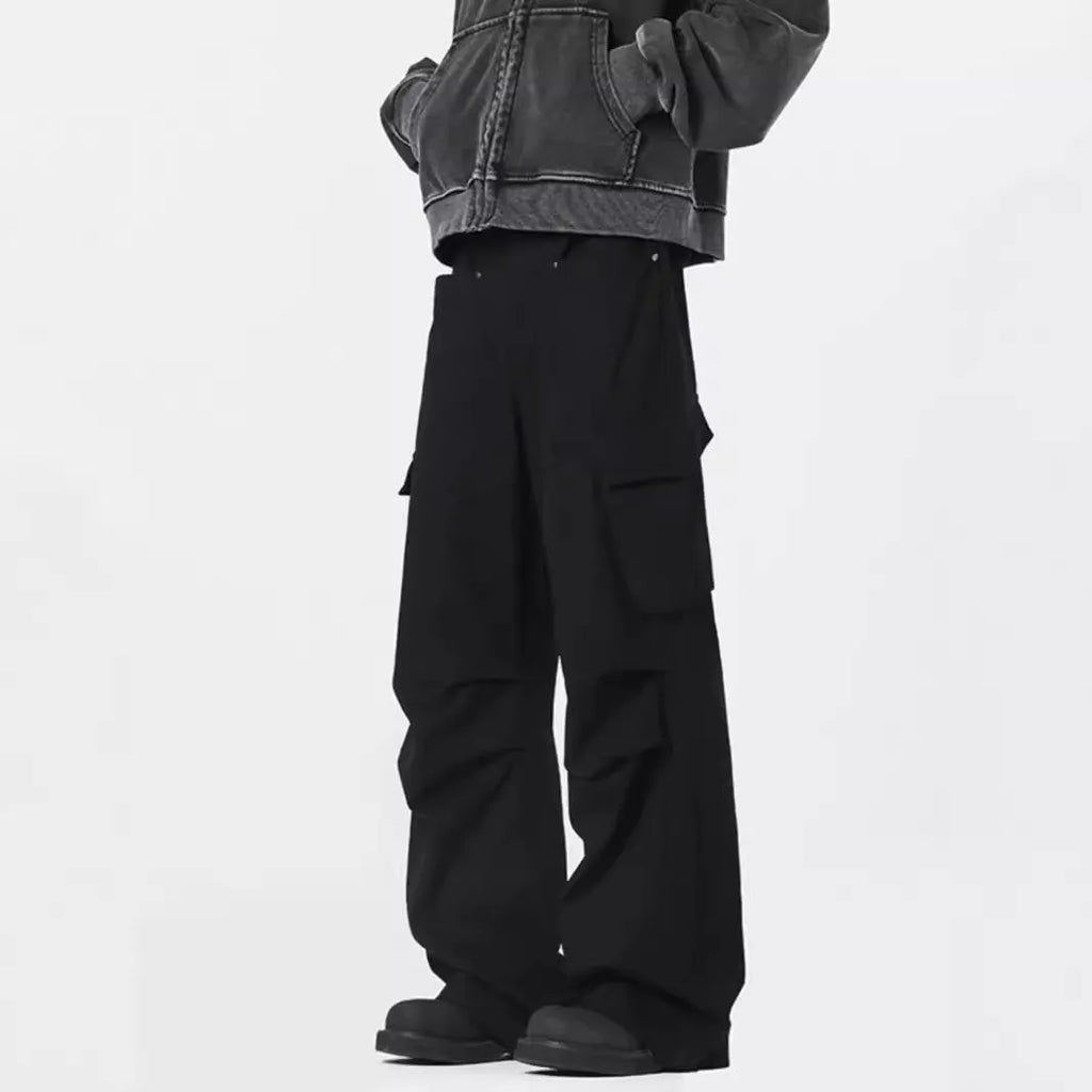 Man wearing black retro high-waist straight-leg casual trousers with a buttoned flap detail.