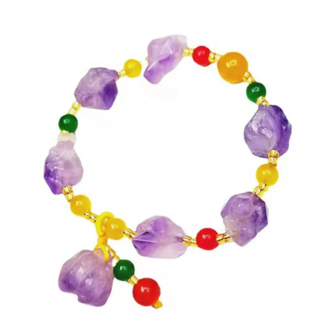 Women's natural shaped violet amethyst bead bracelet with a fu character pendant on a white background.