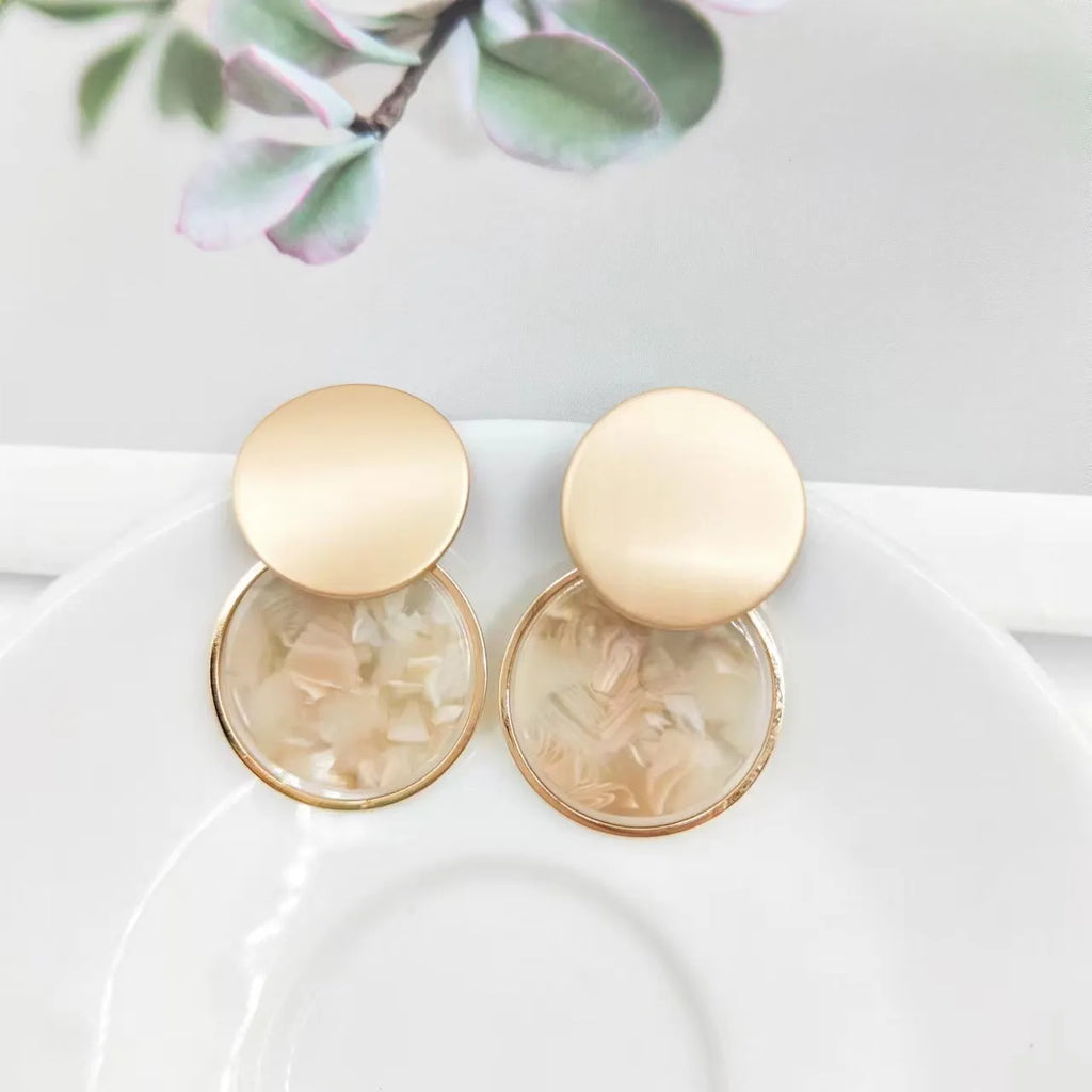 Retro personalized round matte resin female earrings with rotundity shape on a neutral background