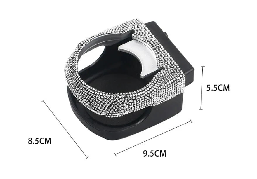 White diamond rhinestone car air vent cup holder bracket on a grey car dashboard.