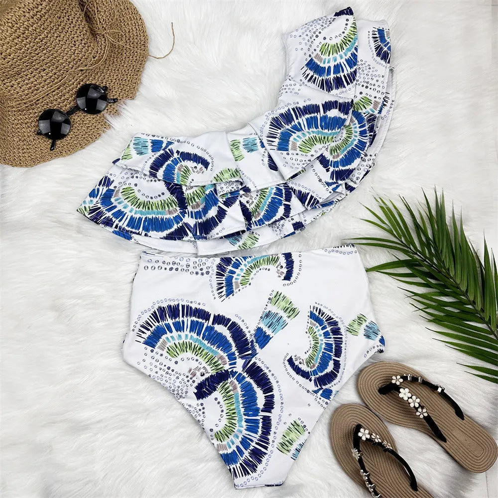White women's one-shoulder bikini with a large double-layer lotus leaf detail and high thigh split.
