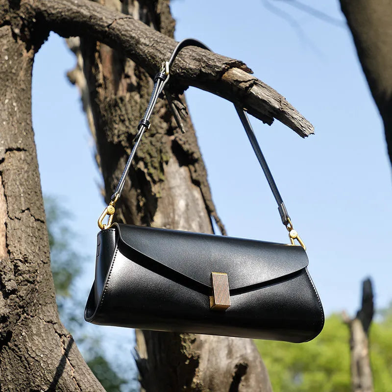 Milky white cowhide leather women's cross-body bag with pillow shape and cross-body strap.