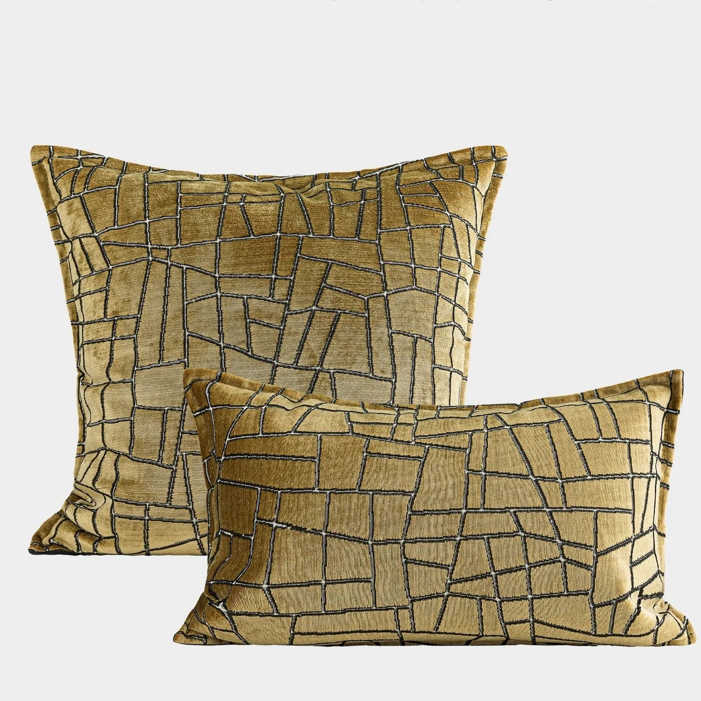 Gold geometric patterned decorative pillow on a grey sofa.