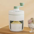 Hand-cranked ice shaving machine in green and orange, with removable ice box and ergonomic handle