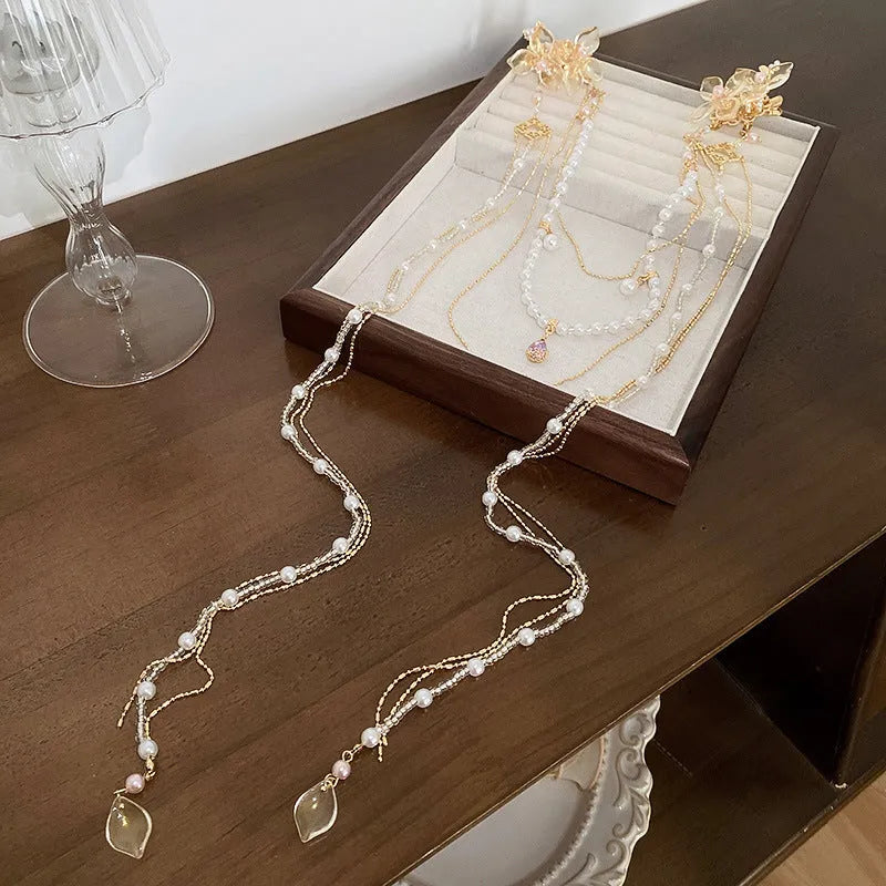 Gold acrylic women's hairpin with flower shape, pearl diamond details, and long tassel design