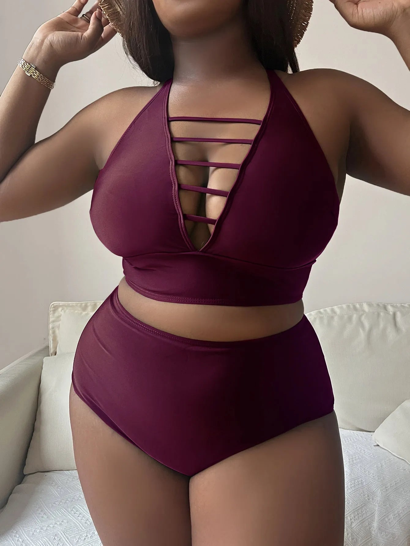 A plus size woman modelling a solid colour halter bikini with adjustable cross-back straps and high-waist briefs.
