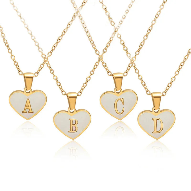 Gold-plated heart necklace with white shell pendant and initial personalisation on a stainless steel chain.