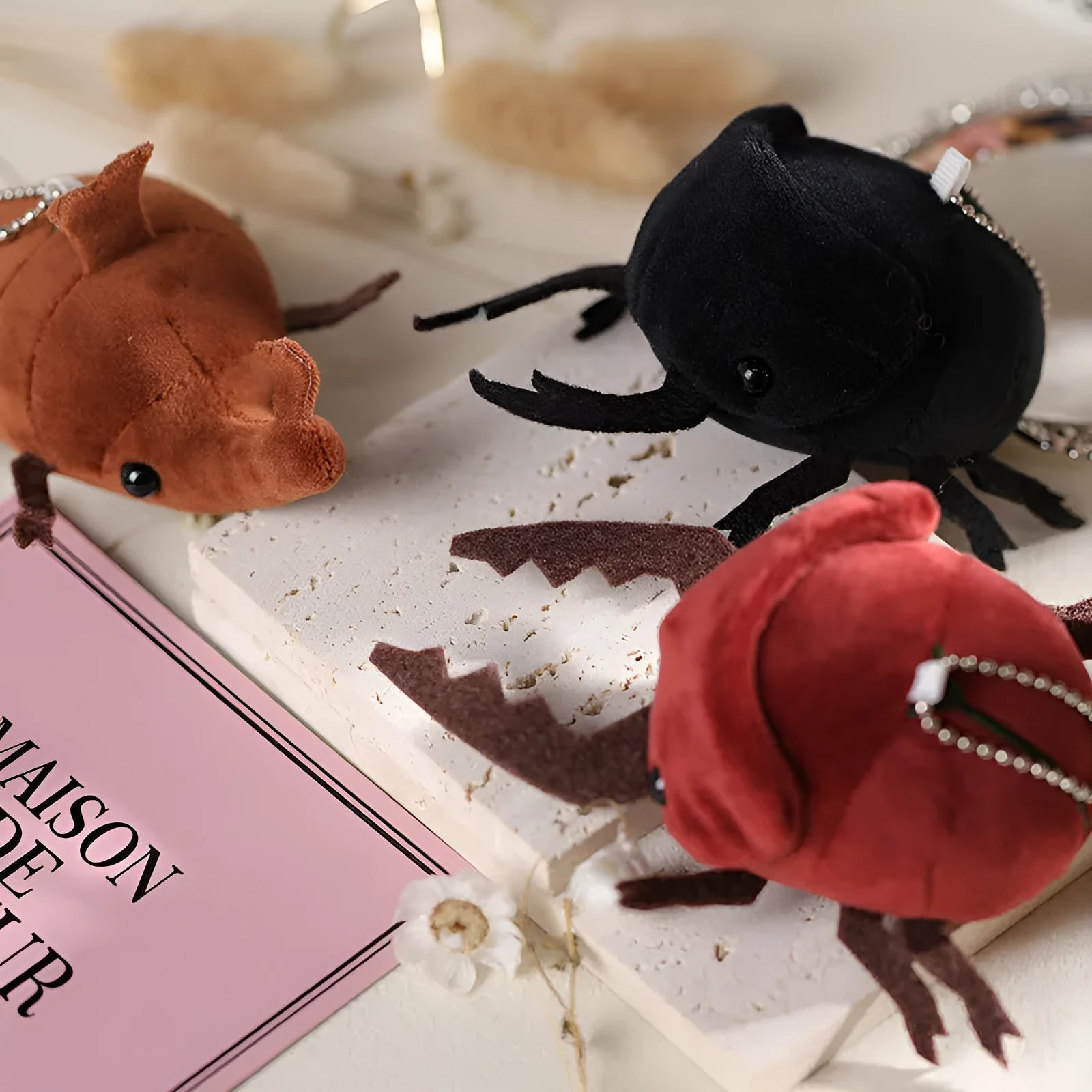 Small black rhinoceros beetle plush doll pendant with horns, 10cm tall, on a white background.