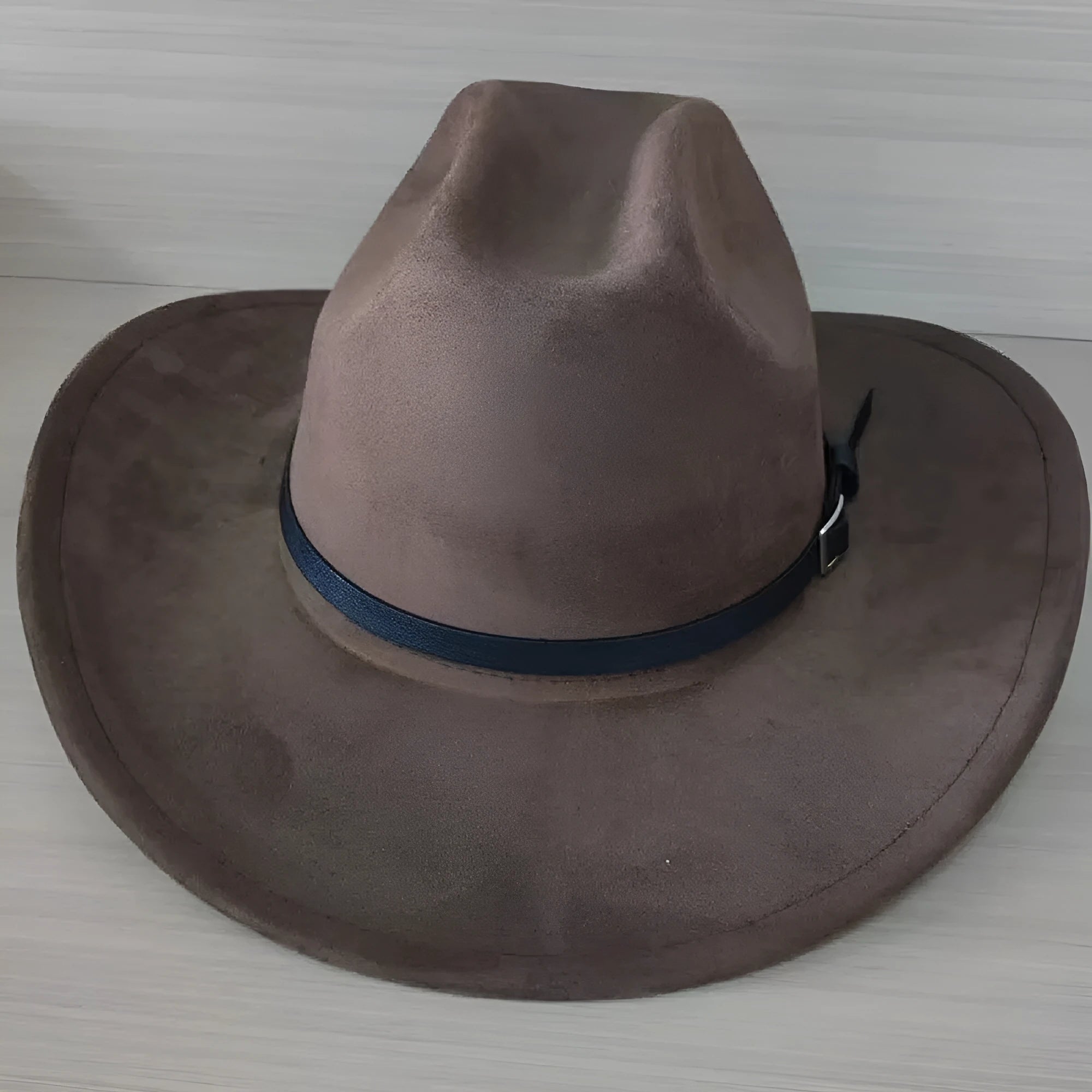 Brown curved edge Western cowboy hat with a conical crown on a wooden post