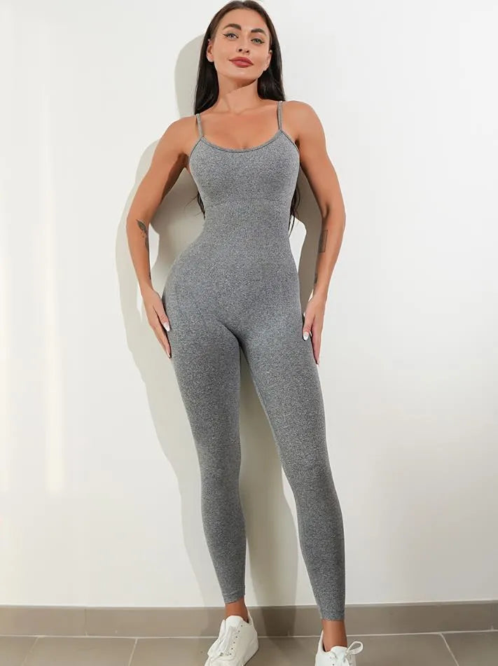 A woman wearing a black sleeveless unitard jumpsuit with spaghetti straps, showing the backless design and close fit.