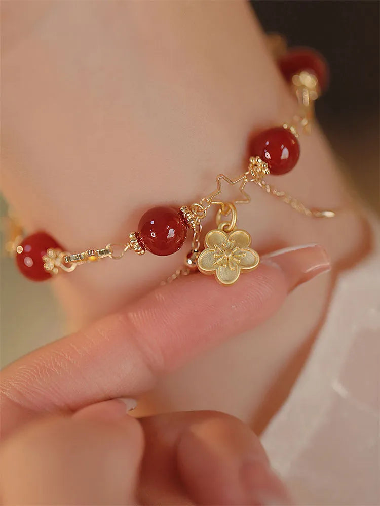 Red agate double layer bracelet with floral and peach blossom design on a wrist