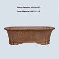 A large rectangular purple sand mud flowerpot with angled segment design on a floor.