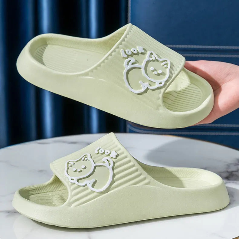 Women's green cat slippers with thick platform sole and flip-flop design on a white background.