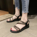 Women's flat casual sandals in gold with rhinestone details and an elastic band.