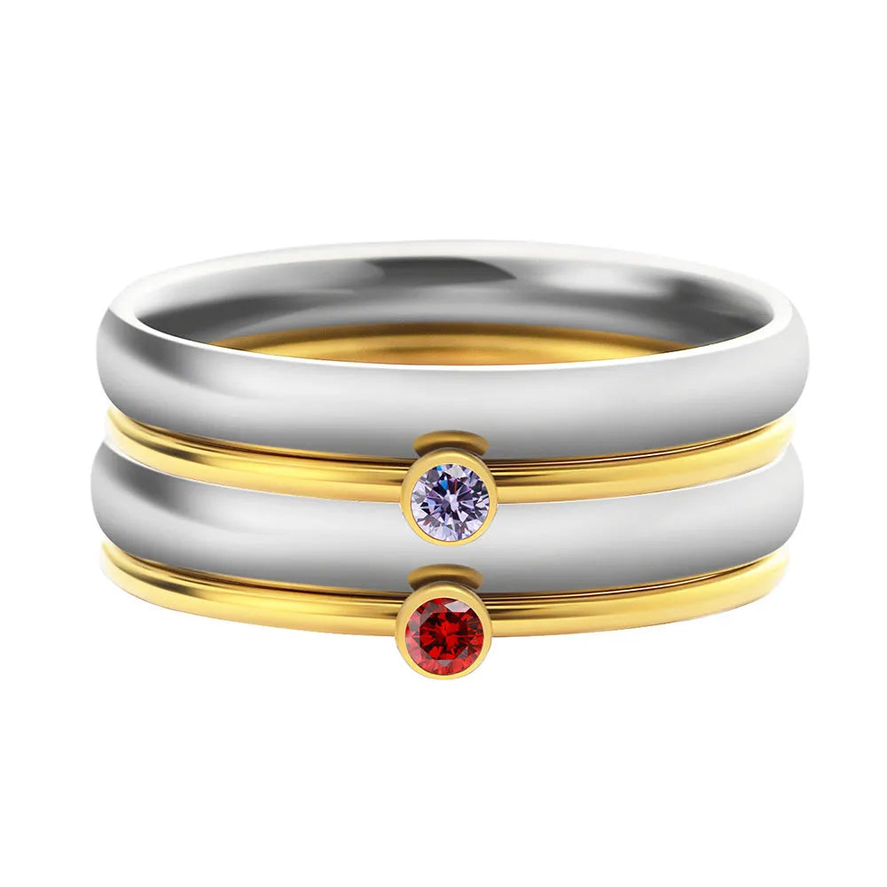 Geometric titanium steel ring with a raised December colour birthstone setting on a gold-toned band.