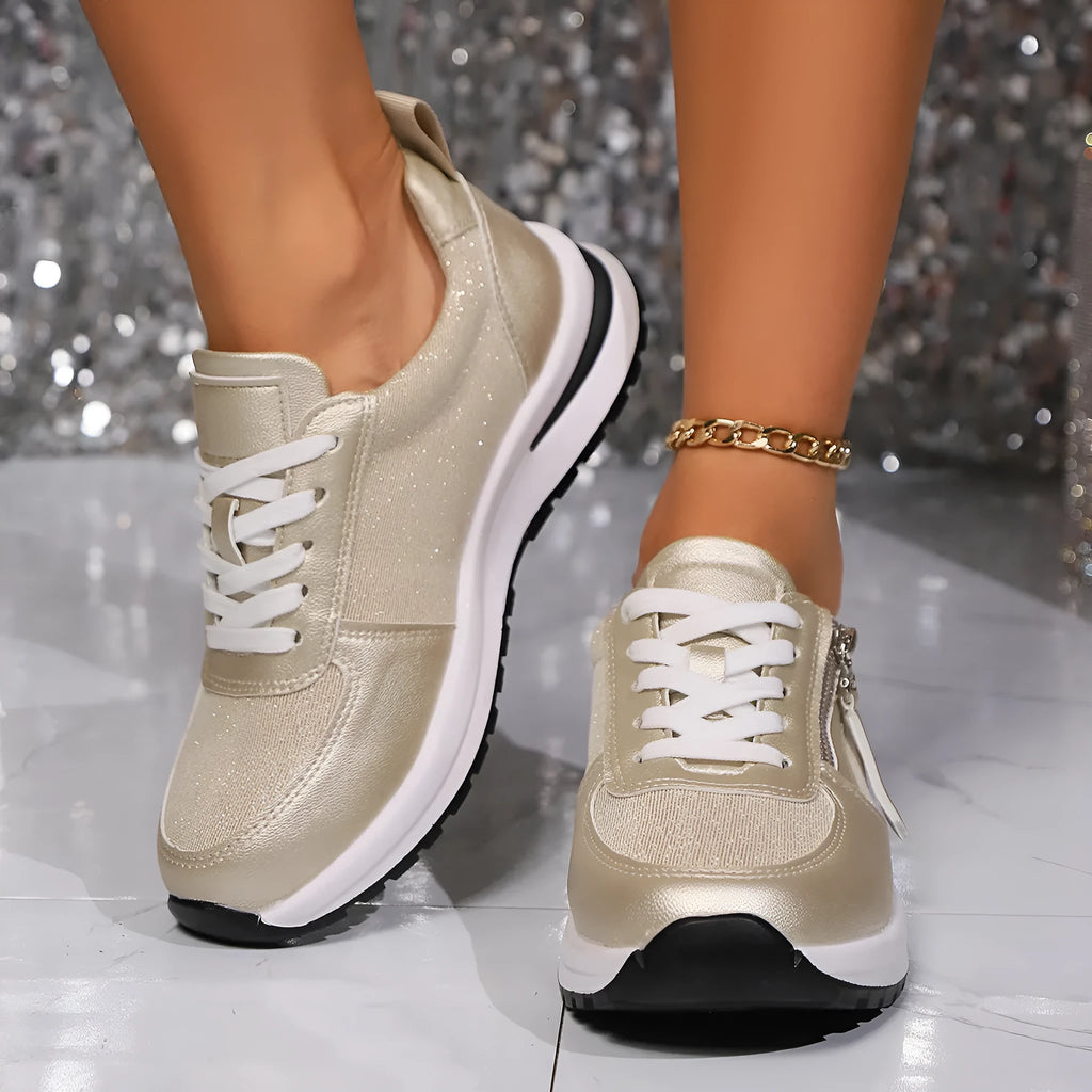 Gold women's lace-up pumps with round toe and flat rubber sole on a white background