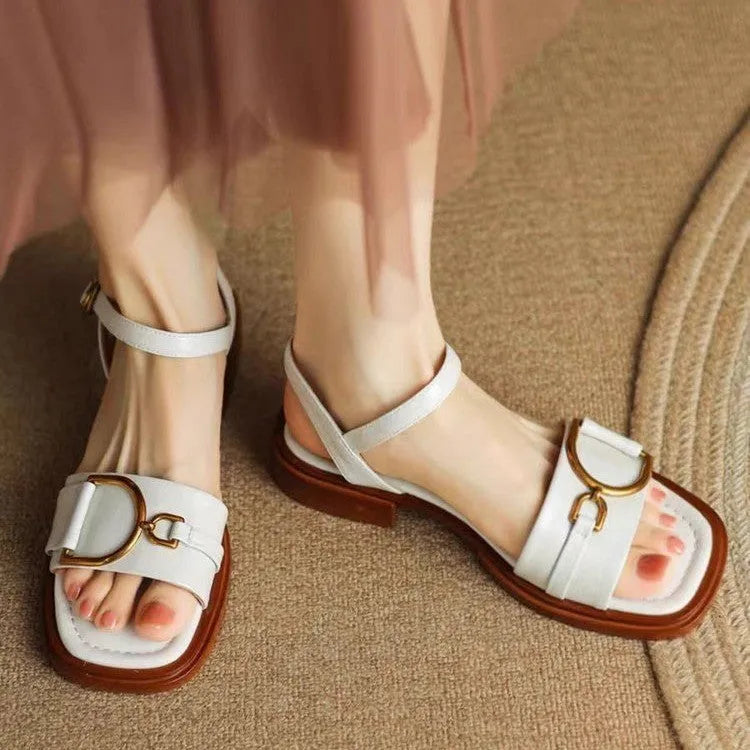 Women's black leather thick-soled sandals with a round toe and buckle closure on a white background