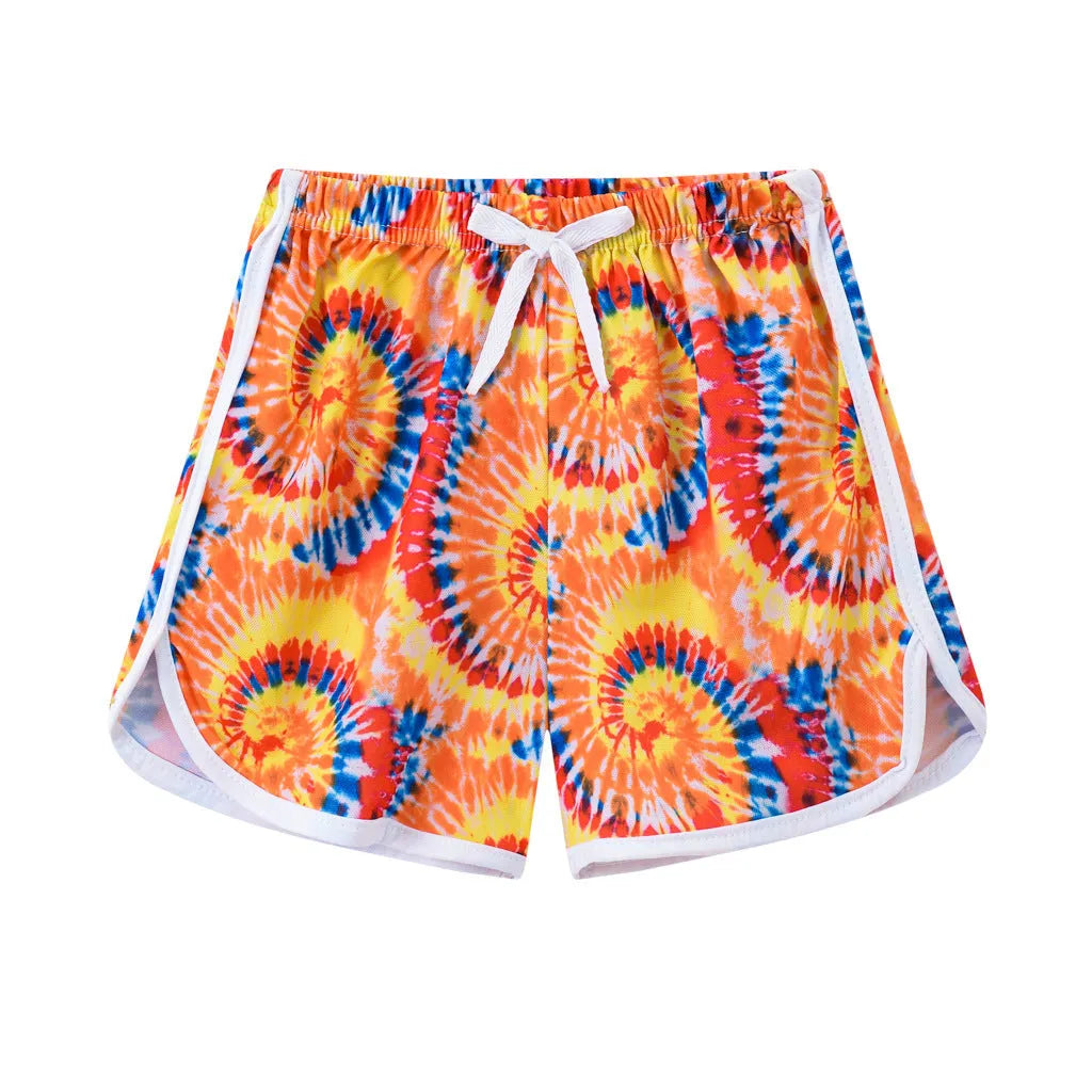 Children's polyester holiday shorts in multiple colours and patterns including stripes, leopard print, and pineapple design.