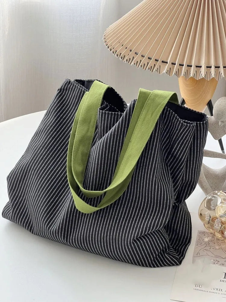 Casual multi-layer canvas tote shoulder bag in a plaid pattern with a wide strap.
