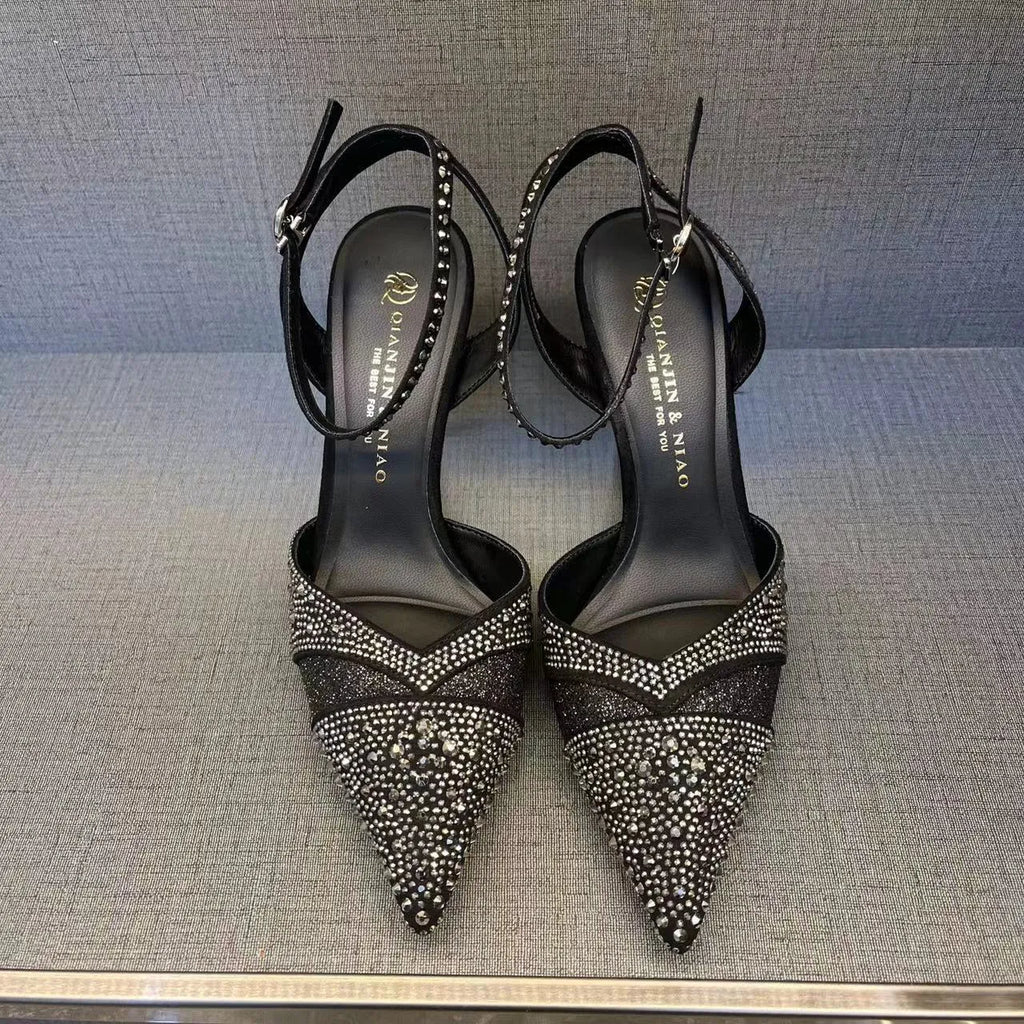 Women's black hollow high heel with stiletto heel, pointed toe, and red sole on a light background.