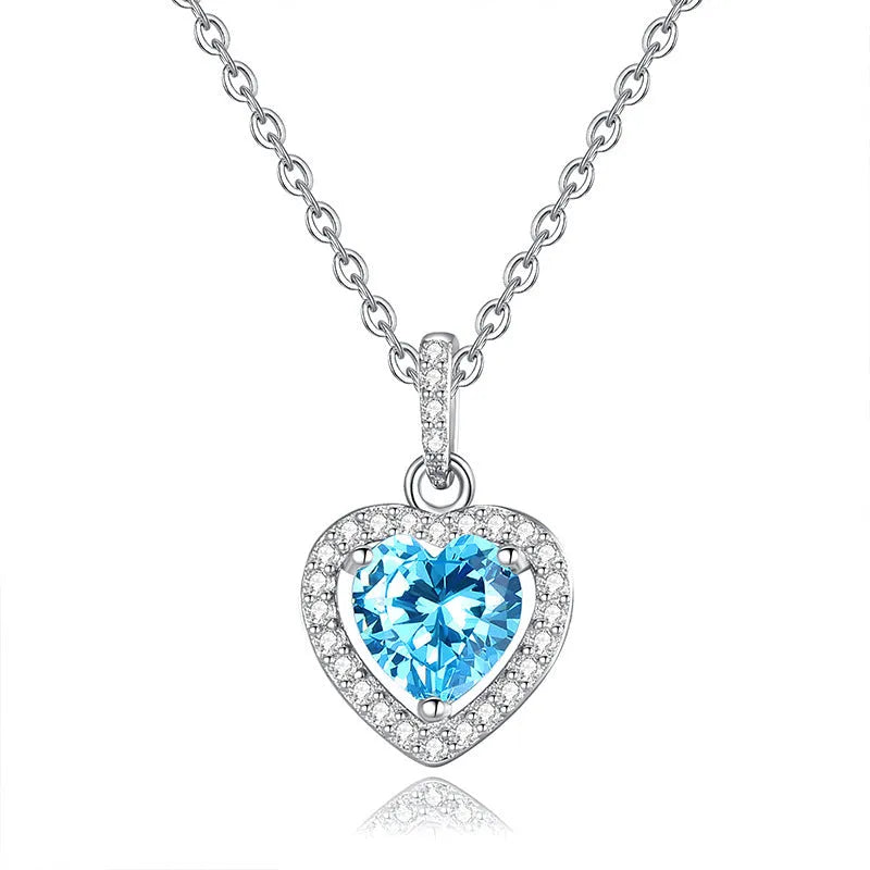 Sterling silver heart pendant necklace with inlaid gemstone on a cross chain for women.