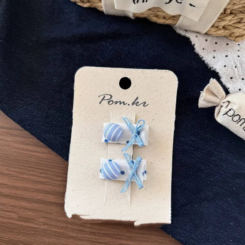 Children's denim handmade flower polka dot bow barrettes with triangle and duckbill clips on a light background
