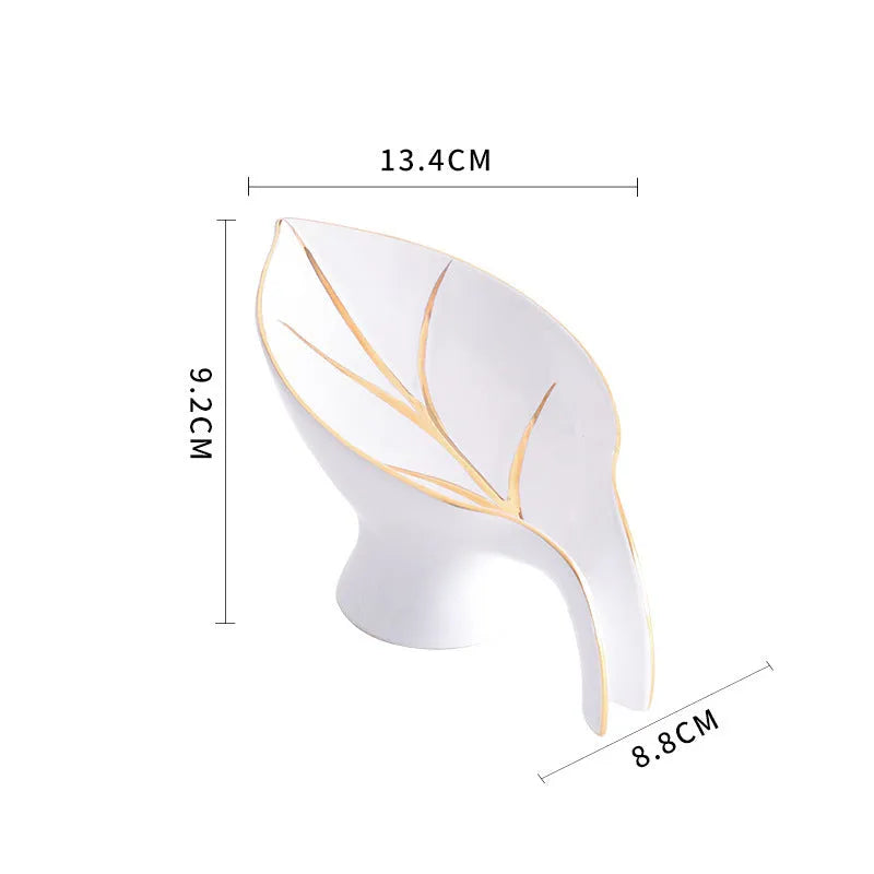 Ceramic leaf shape soap dish with hollow draining base and suction cup, black colour, on bathroom tiles