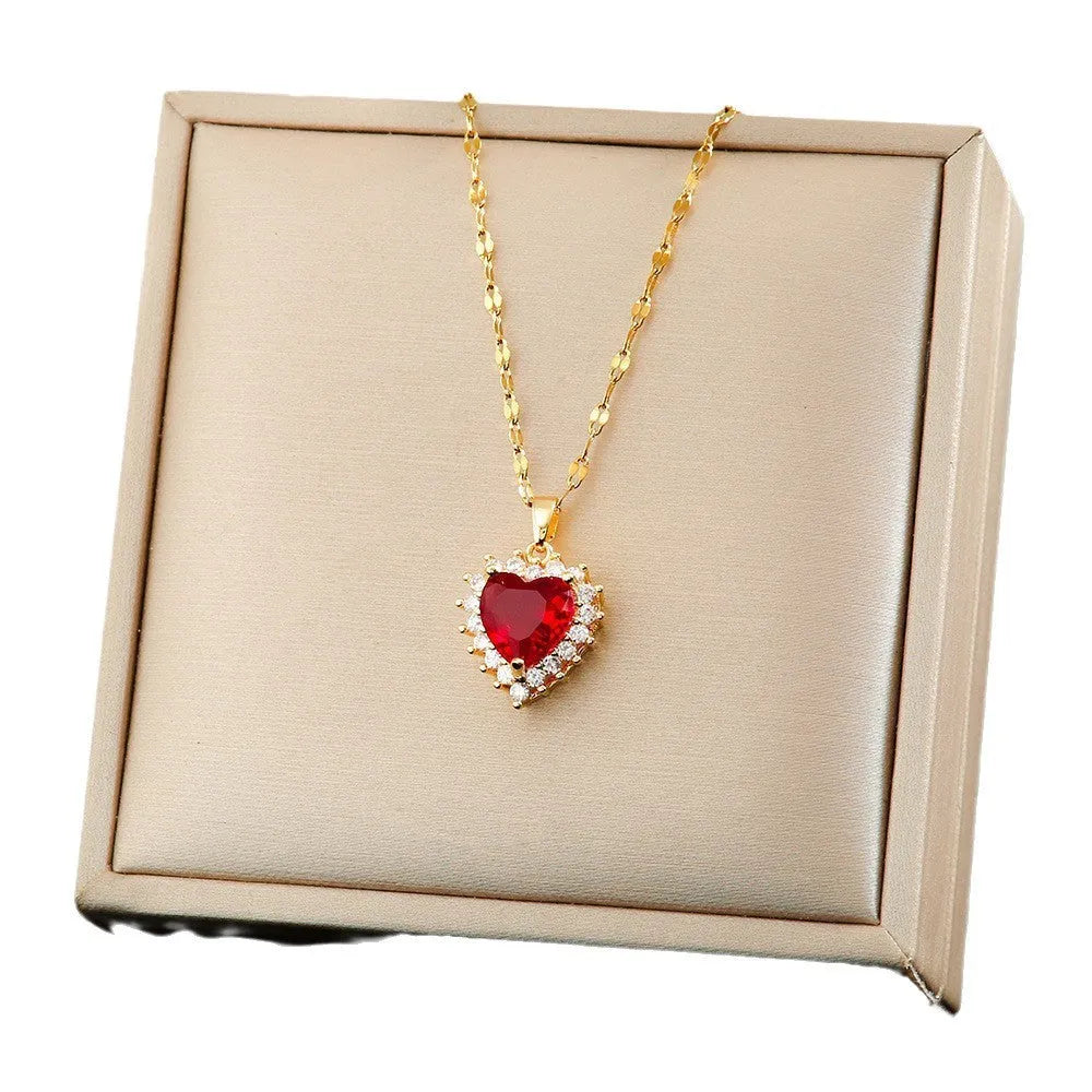 Gold red titanium steel necklace with heart pendant and gemstone inlay, part of a matching jewellery suit.