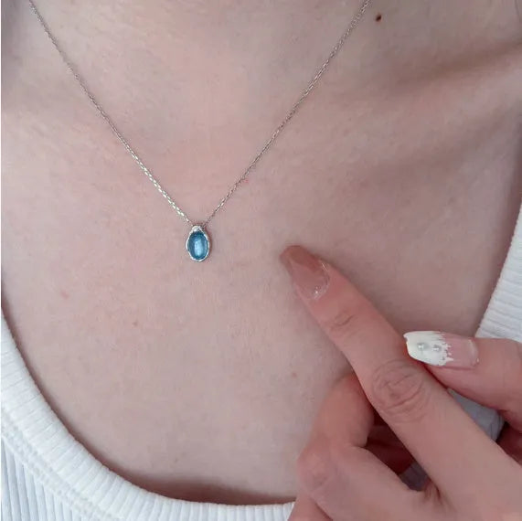 Navy blue water drop pendant necklace with platinum-coloured copper chain on display