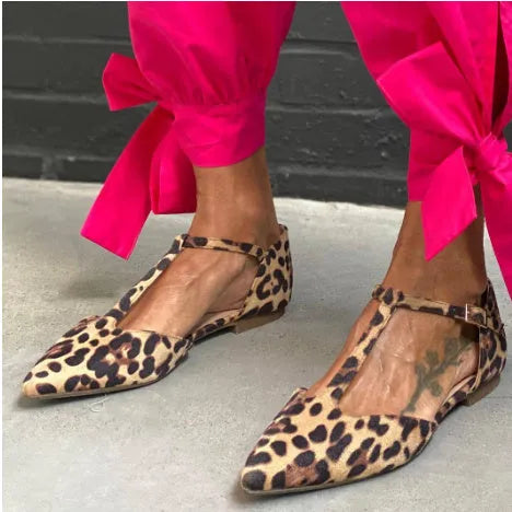 Leopard print women's pointed toe pumps with a cross strap and a low chunky heel.