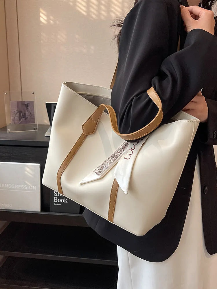 Large capacity tote crossbody bag in bucket style with sandwich pocket design and visible sewing details