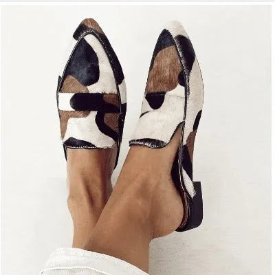 Women's black and white apricot retro pointed-toe flats with animal print suede upper and low heel.