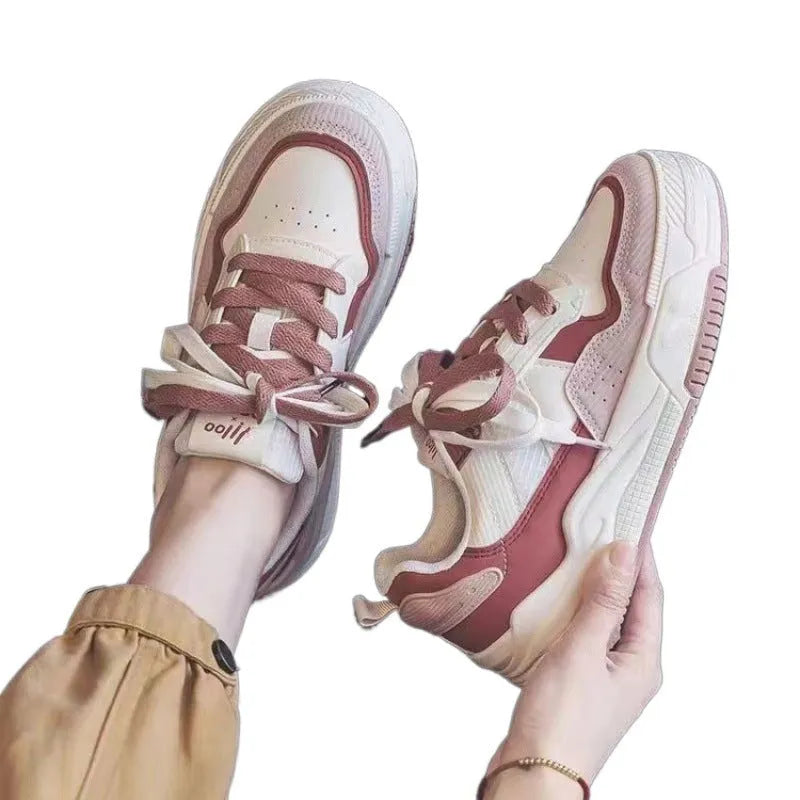 Women's beige and pink low-top lace-up sneakers with a rubber sole on a white background.