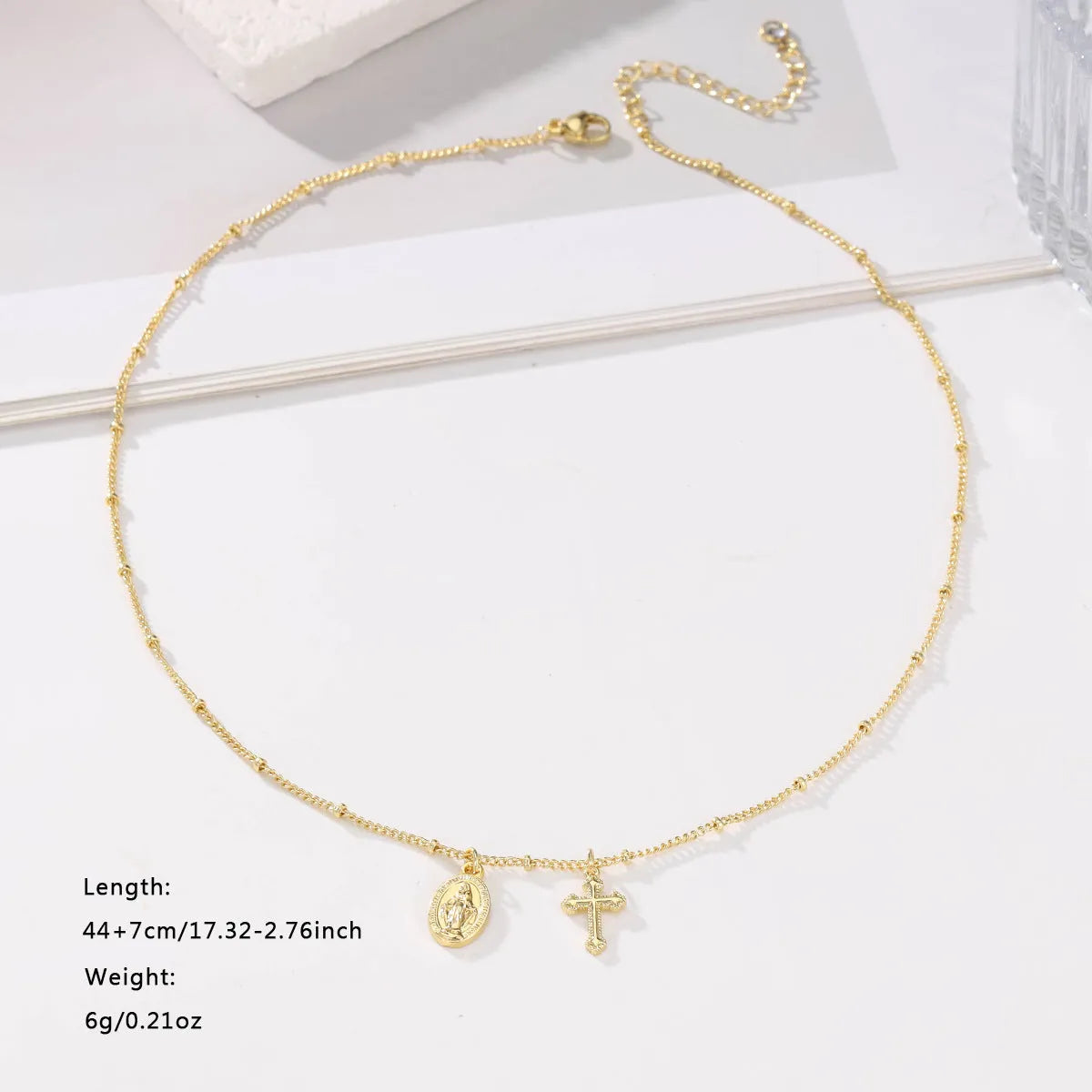 Gold geometric Virgin Mary cross necklace on a chain, simple style.