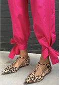 Leopard print women's pointed toe pumps with a cross strap and a low chunky heel.